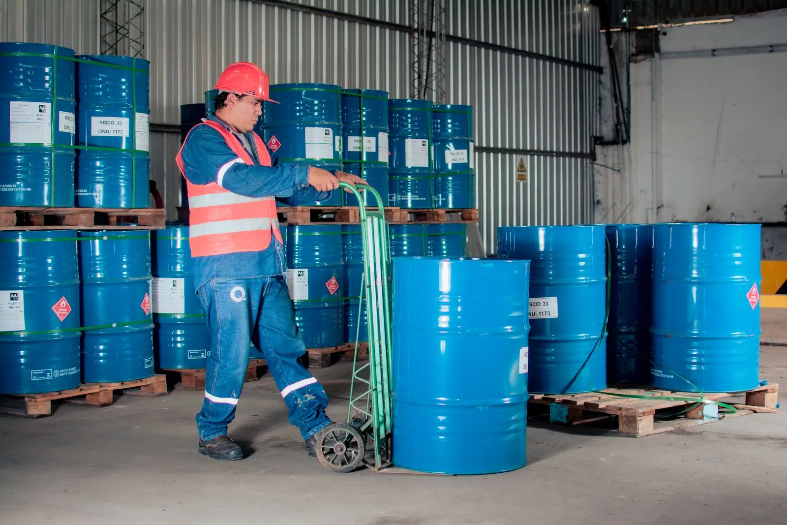 Worker handling drums in a lubricants warehouse