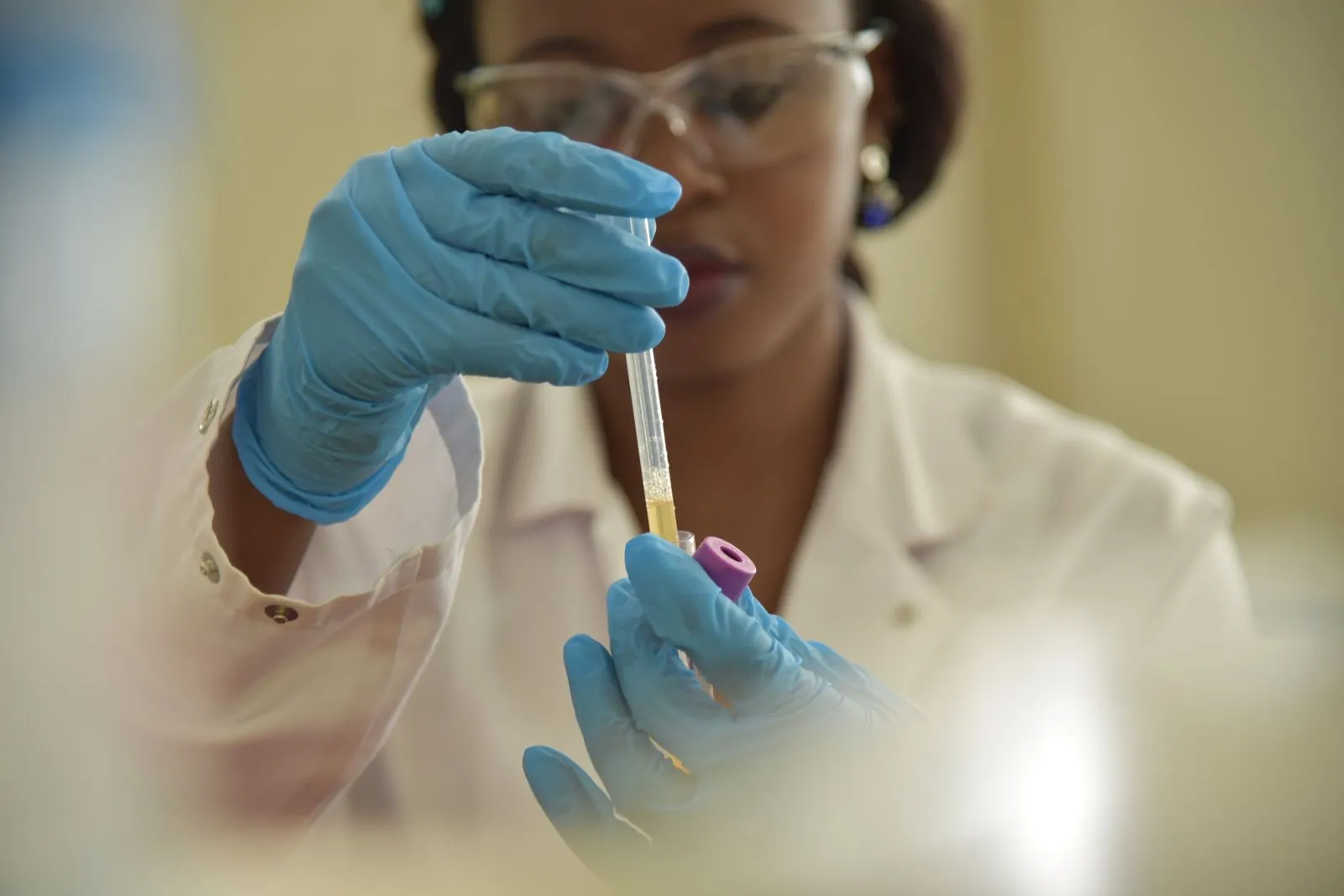 Analyst examining a fuel sample vial in a testing laboratory