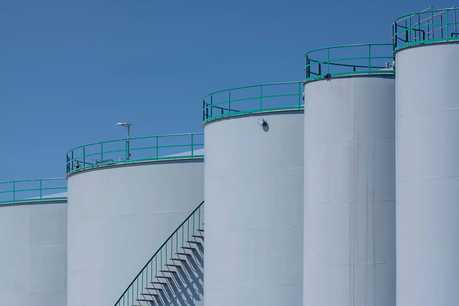 White petroleum storage tanks with access stairways